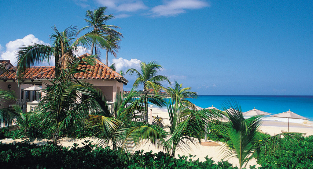 Beachfront resort residence with palm trees and turquoise water